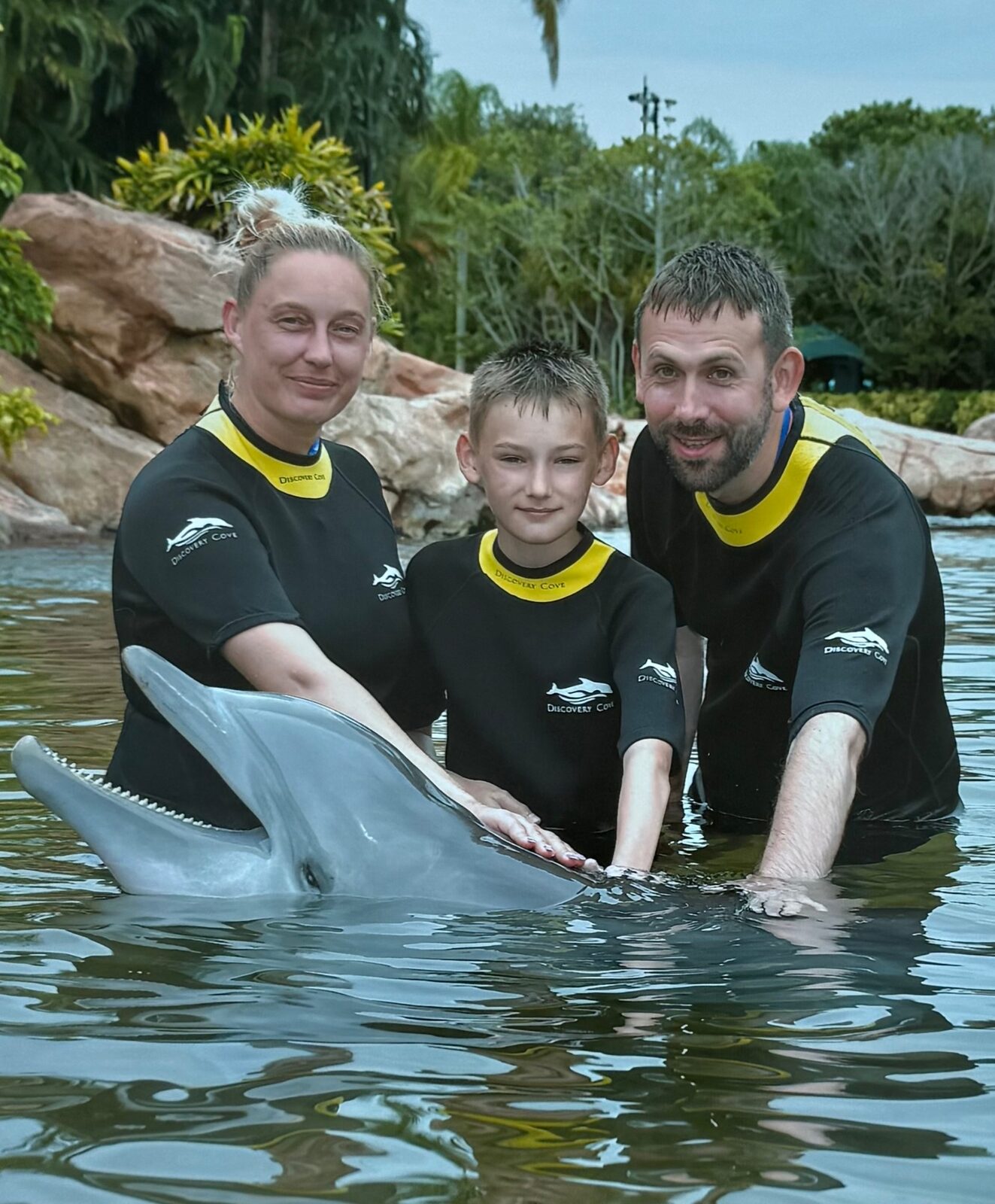 Will, Amie and Austin meeting a dolphin at Discovery Cove in Orlando